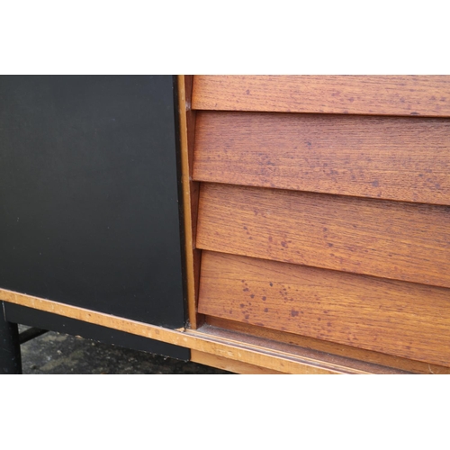 539 - A 1960s teak and ebonised panel sliding door sideboard, fitted five centre drawers, on ebonised turn... 