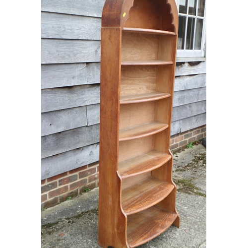 542 - A 1930s oak bowfront arch top waterfall open bookcase, on panel end supports, 23