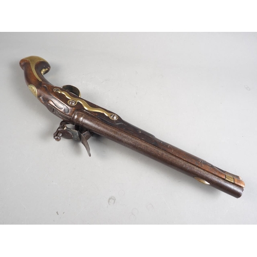 146 - An 18th century flintlock pistol with brass mounts and monogram to stock barrel, 11 1/2