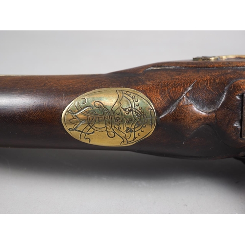 146 - An 18th century flintlock pistol with brass mounts and monogram to stock barrel, 11 1/2