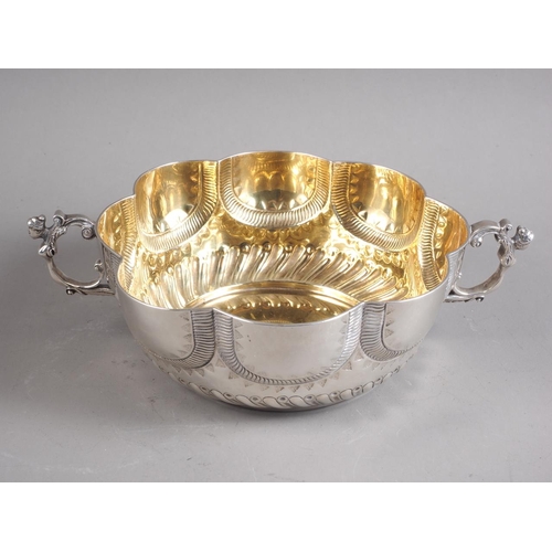 240 - A silver shaped rim, two handled bowl of 17th century design with embossed decoration, 10 1/4