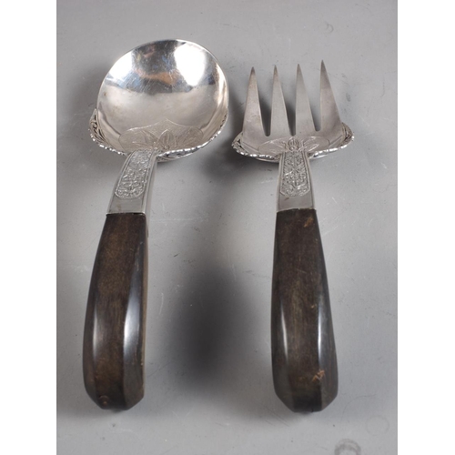 242 - A pair of Eastern, white metal salad servers with horn pistol grip handles