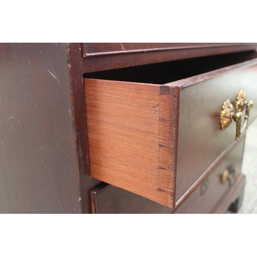 441 - A George III mahogany chest of four long graduated drawers with gilt brass bail handles, on bracket ... 