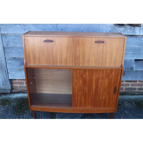 503 - A 1960s Doncraft teak desk/cocktail cabinet with two fall front compartments over one glass and one ... 