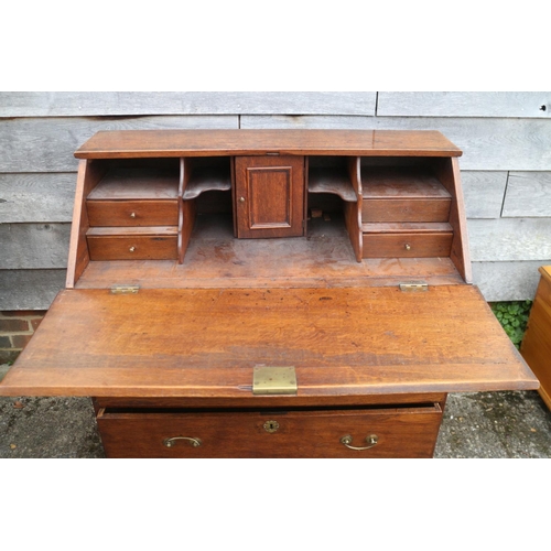 522 - An early 20th century oak fall front bureau, the interior fitted cupboard, drawers and pigeon holes,... 