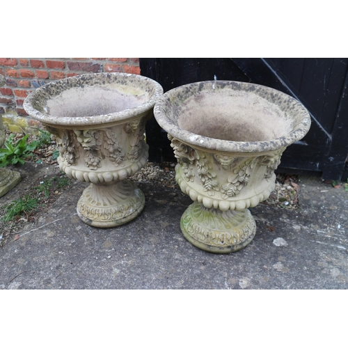 604 - A pair of cast stone campana urns with swag decoration, 20