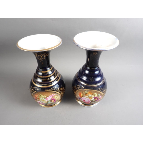 17 - A pair of early 19th century bone china vases with flared rims and floral reserve panels on a blue g... 