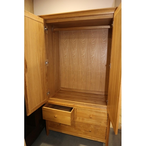 517 - A modern oak wardrobe enclosed two doors over two small and one long drawer, on style supports, 44