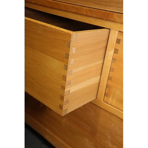 517 - A modern oak wardrobe enclosed two doors over two small and one long drawer, on style supports, 44