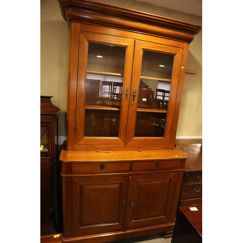 520 - A cherrywood bookcase, the upper section enclosed two glazed panelled doors over two drawers and cup... 