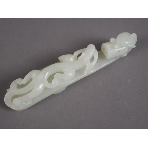 88 - A Chinese carved pale green jade belt loop, formed as a dragon, 4 1/2