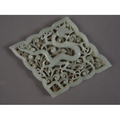 89 - A Chinese carved jade diamond shaped plaque with dragon and scrolled decoration, 4 3/4