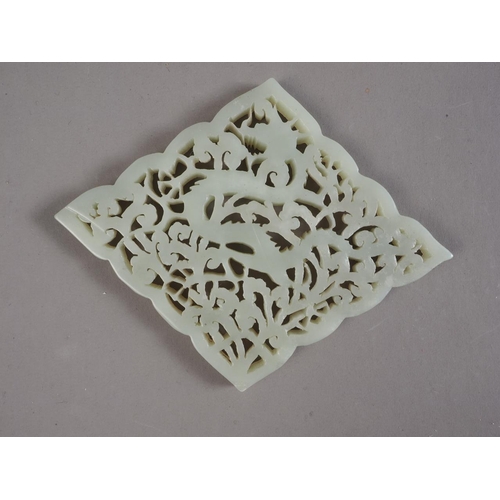 89 - A Chinese carved jade diamond shaped plaque with dragon and scrolled decoration, 4 3/4