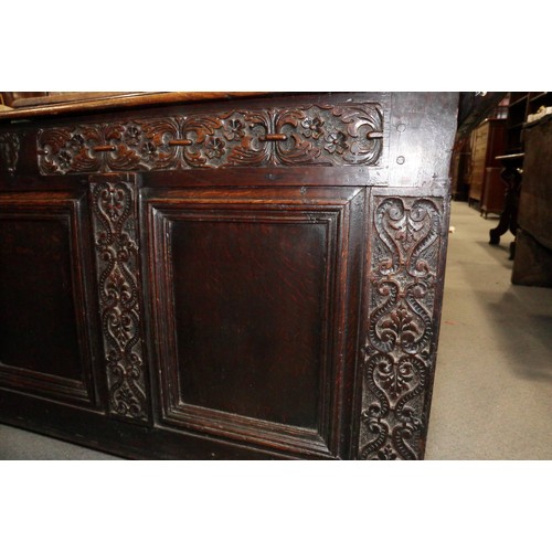 417 - An early 18th century carved oak triple panel front coffer with scroll design and planked top, on st... 