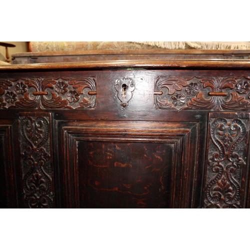 417 - An early 18th century carved oak triple panel front coffer with scroll design and planked top, on st... 