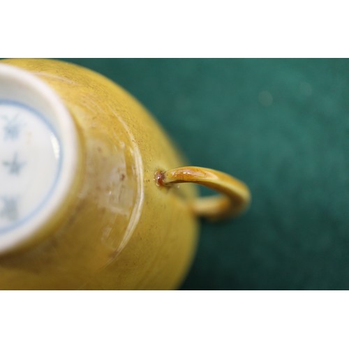 71 - A Chinese yellow glazed two-handled cup with incised beast decoration and six-character mark to base... 