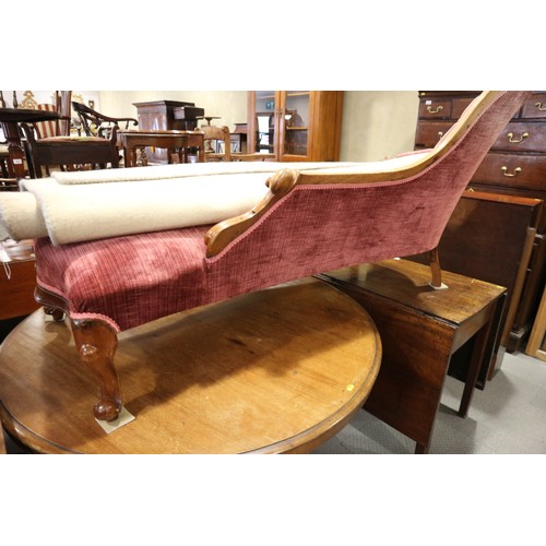 438 - A late Victorian carved walnut showframe chaise longue, upholstered in a claret velour, on cabriole ... 