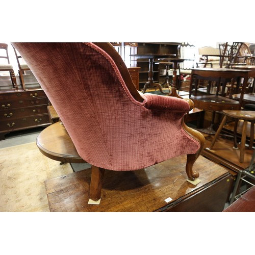 438 - A late Victorian carved walnut showframe chaise longue, upholstered in a claret velour, on cabriole ... 