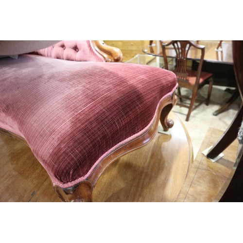 438 - A late Victorian carved walnut showframe chaise longue, upholstered in a claret velour, on cabriole ... 