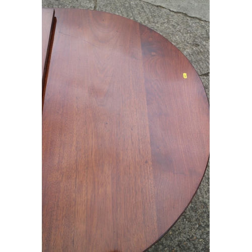 535 - A mahogany double pedestal dining table of Georgian design with one extra leaf, on twin turned colum... 