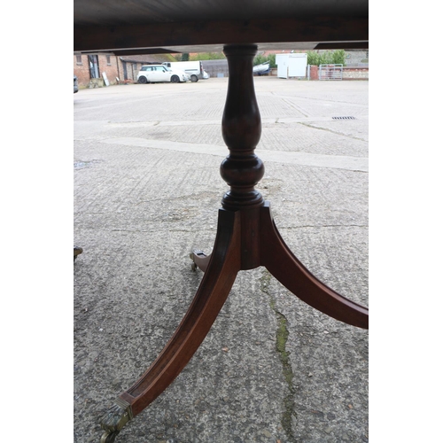 535 - A mahogany double pedestal dining table of Georgian design with one extra leaf, on twin turned colum... 