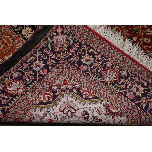 598 - A Qum silk pile rug with geometric central medallion on a rust ground and multi-border in shades of ... 