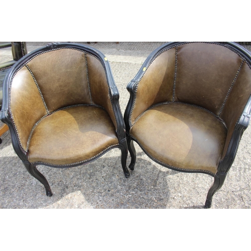 492 - A pair of ebonised tub chairs with green leather seats, on cabriole supports