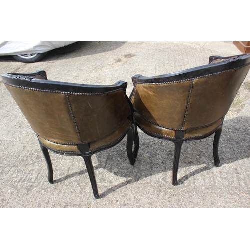 492 - A pair of ebonised tub chairs with green leather seats, on cabriole supports