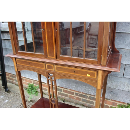 561 - An Edwardian walnut and satinwood banded display cabinet with raised back over two Gothic lattice do... 