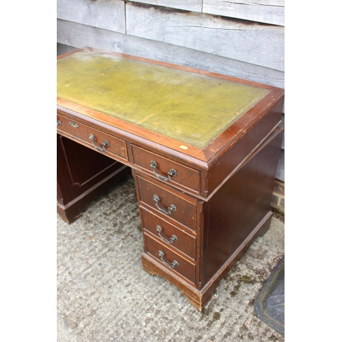 565 - An oak double pedestal desk with green tooled lined top, fitted nine drawers, on bracket feet, 48