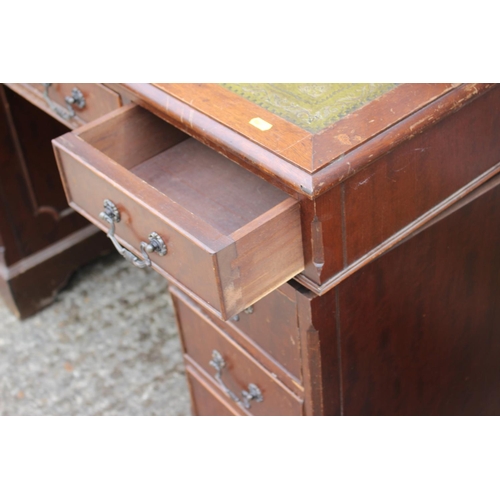 565 - An oak double pedestal desk with green tooled lined top, fitted nine drawers, on bracket feet, 48