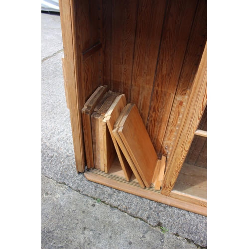 586 - A waxed pine bookcase enclosed three sliding glazed panel doors, 68