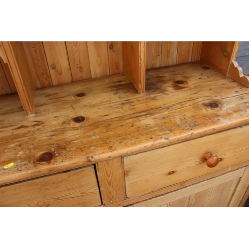 588 - A waxed pine dresser, the upper section with arcade and four spice drawers over two drawers and cupb... 