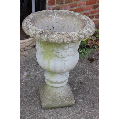 644 - A cast stone campana planter with floral decoration, 19