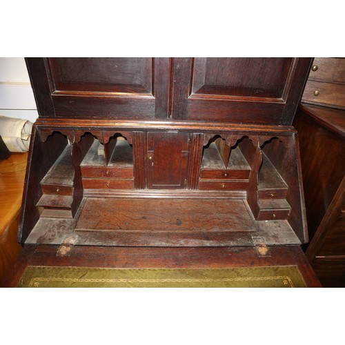 415 - An 18th century oak bureau bookcase, the upper section enclosed panelled doors over fitted writing c... 