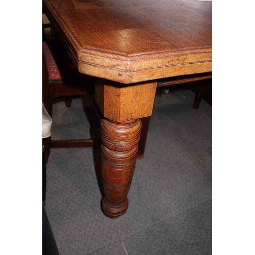 445 - A late Victorian walnut extending dining table with cut corners and extra leaf, on turned supports, ... 