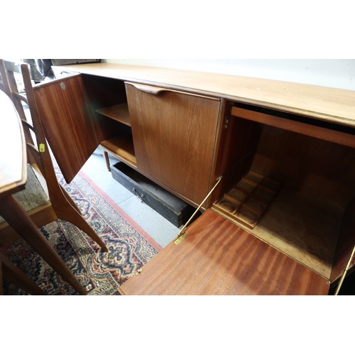 554 - A 1960s McIntosh sideboard, fitted three drawers and three doors enclosed shelves, cellarette and a ... 