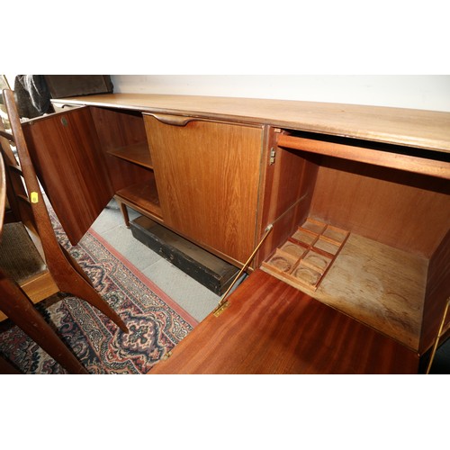 554 - A 1960s McIntosh sideboard, fitted three drawers and three doors enclosed shelves, cellarette and a ... 