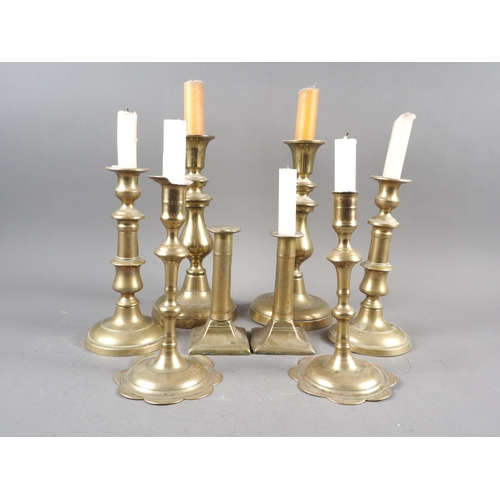 117 - A pair of 18th century brass petal base candlesticks, and three other pairs of brass candlesticks