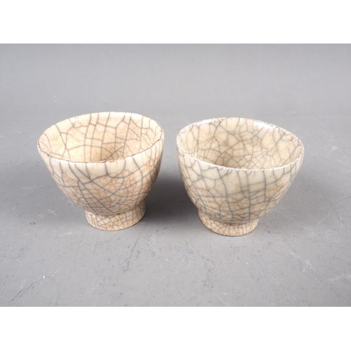 70 - A pair of cream crackle glaze pottery tea bowls, 1 1/2