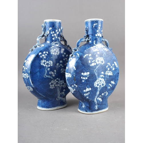 79 - A pair of Chinese blue and white moon flasks with relief dragon handles and prunus decoration, four-... 