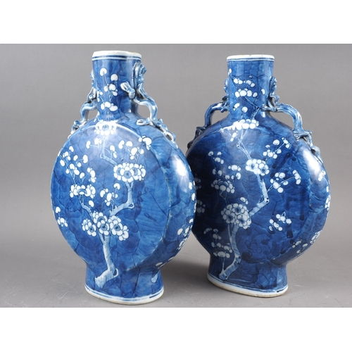 79 - A pair of Chinese blue and white moon flasks with relief dragon handles and prunus decoration, four-... 