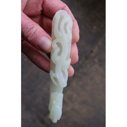 82 - A Chinese carved pale green jade belt loop, formed as a dragon, 4 1/2