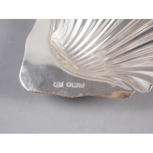 242 - A silver shell-shaped butter dish, a silver toast rack, a cream jug, a mug, a bonbon dish with pierc... 