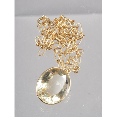 290 - A large faceted oval citrine in gold plated frame and necklace