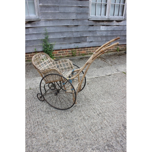 642 - A child's late 19th/early 20th century bamboo, wicker and green painted iron perambulator, 32