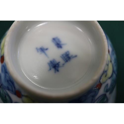 86 - A pair of Chinese teacups with floral and leaf decoration, four-character marks to bases, 3 1/4