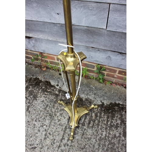 242 - A brass adjustable standard lamp, on triform base