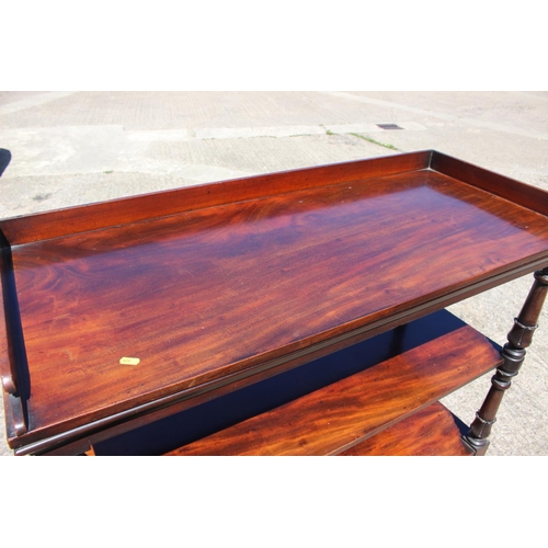 416 - A mahogany three-tier buffet table with raised back and sides, on turned, shaped and castored suppor... 