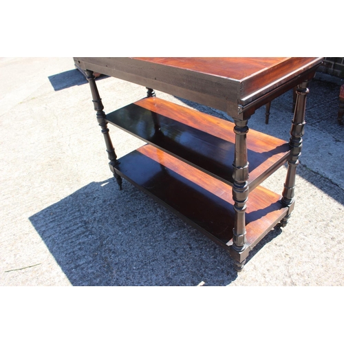 416 - A mahogany three-tier buffet table with raised back and sides, on turned, shaped and castored suppor... 